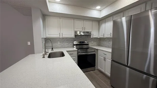 a kitchen with a refrigerator sink and stove