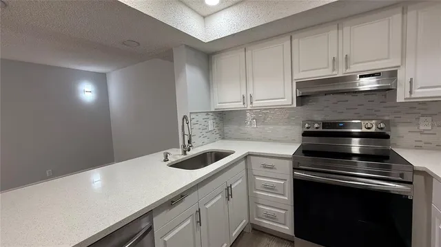 a kitchen with white cabinets stainless steel appliances and sink