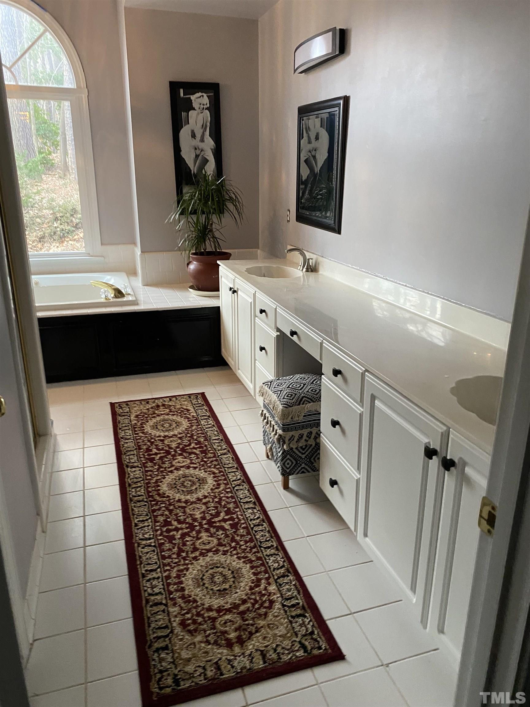 2813 Hawtree Drive Raleigh, NC 27613 - Photo 8 of 15 a bathroom with a sink a mirror and a bathtub