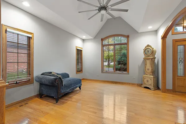 an empty room with windows and ceiling fan