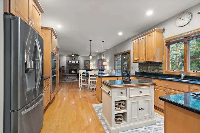a kitchen with stainless steel appliances granite countertop a refrigerator and a sink