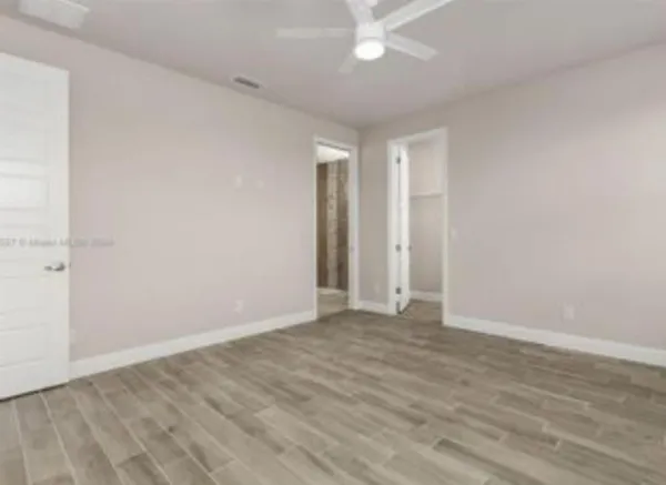 a view of an empty room with wooden floor