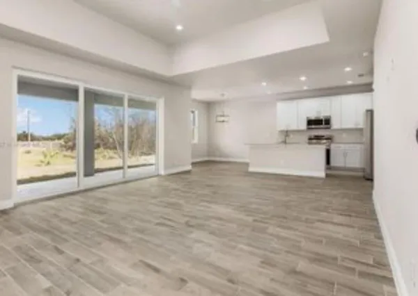 a view of large kitchen with granite countertop cabinets and refrigerator