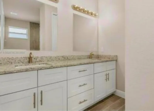 a bathroom with a granite countertop sink and vanity
