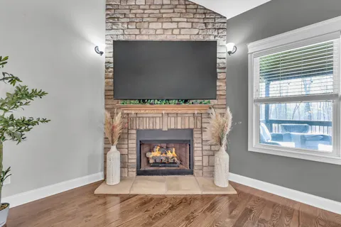 a view of a living room and kitchen with furniture wooden floor and a large window
