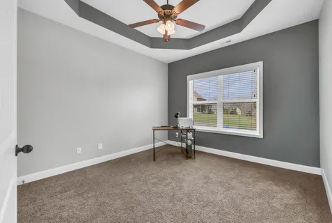 a bedroom with a bed a table and a large window