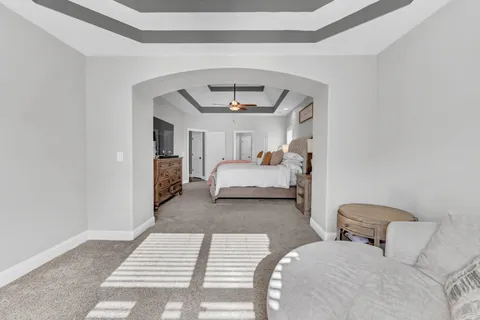 a bedroom with a large bed and a chandelier