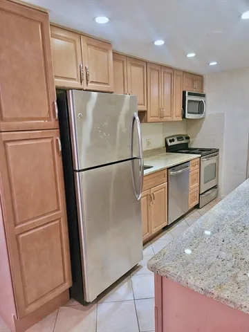 a kitchen with granite countertop stainless steel appliances a refrigerator a sink and a refrigerator