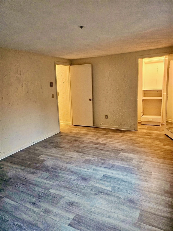 220 Swanson Road, Unit 606 Boxborough, MA 01719 - Photo 7 of 11 a view of an empty room with wooden floor and a window