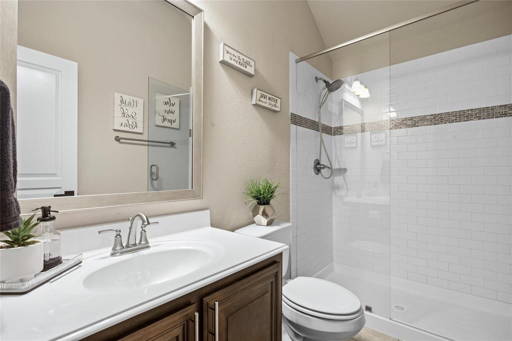 1802 Roundtree Road Forney, TX 75126 - Photo 36 of 39 a bathroom with a sink toilet vanity and shower