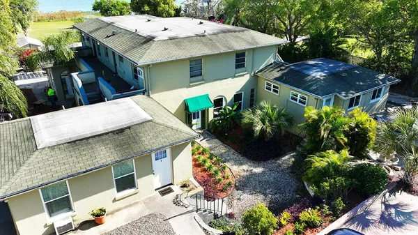 a view of a house with a yard and potted plants