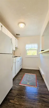 a view of a kitchen with wooden floor and electronic appliances