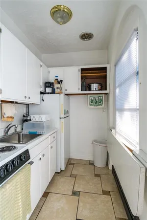 a kitchen with a sink a stove cabinets and a window