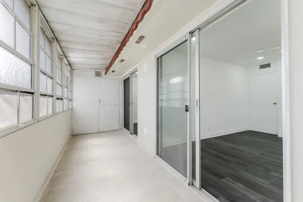 an empty room with wooden floor and ceiling fan