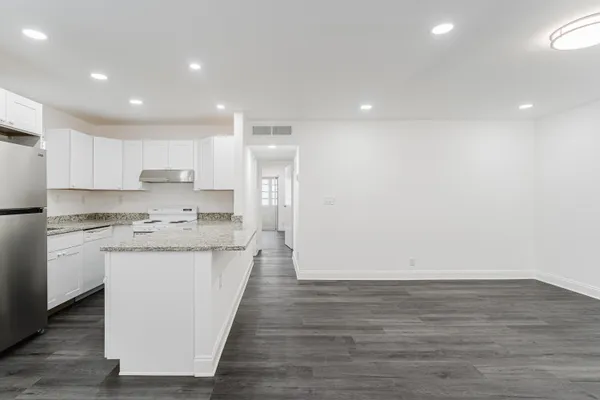 a kitchen with stainless steel appliances granite countertop a refrigerator and a stove top oven