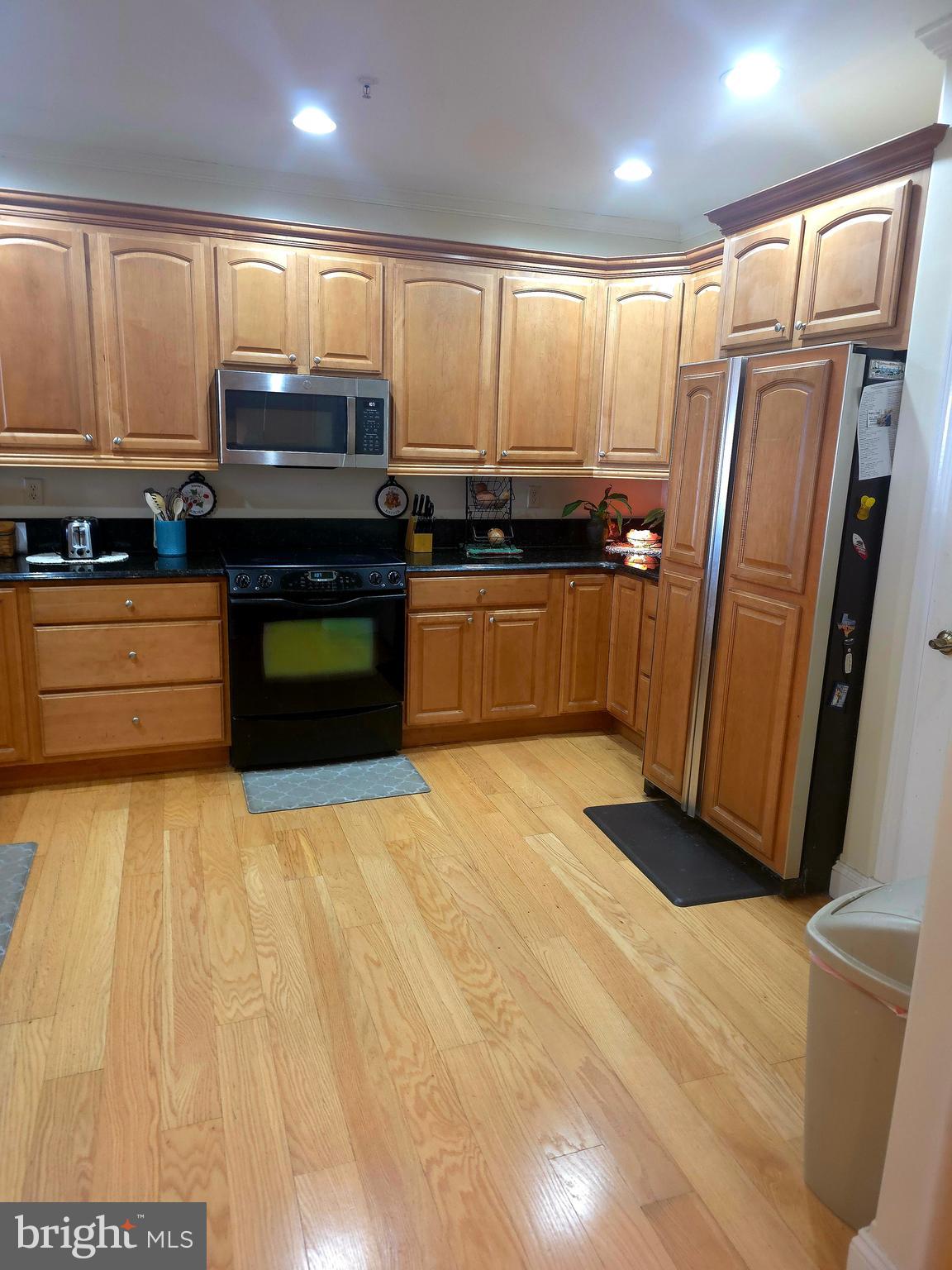 2102 Points Reach, Unit 2102 Berlin, MD 21811 - Photo 8 of 36 a kitchen with granite countertop a refrigerator and a stove top oven