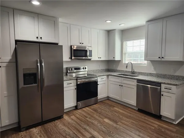 a kitchen with granite countertop cabinets stainless steel appliances and a window