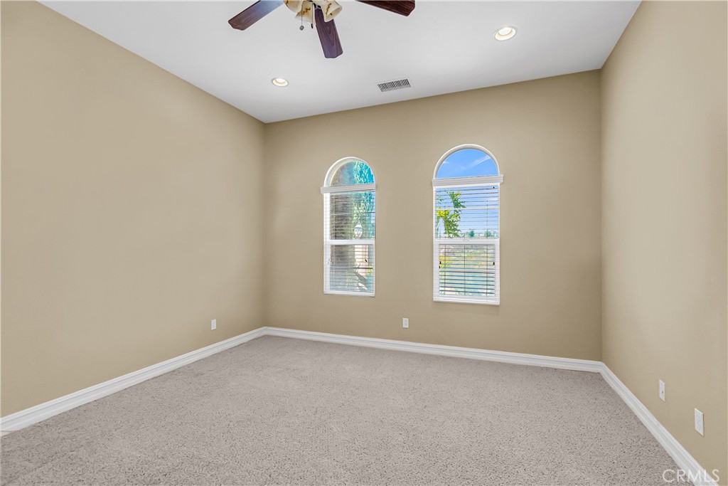 7780 Solitude Court Riverside, CA 92506 - Photo 13 of 63 an empty room with windows and chandelier fan