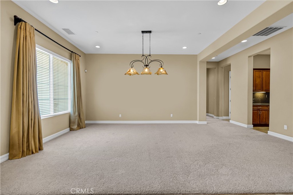 7780 Solitude Court Riverside, CA 92506 - Photo 18 of 63 an empty room with chandelier windows and cabinet