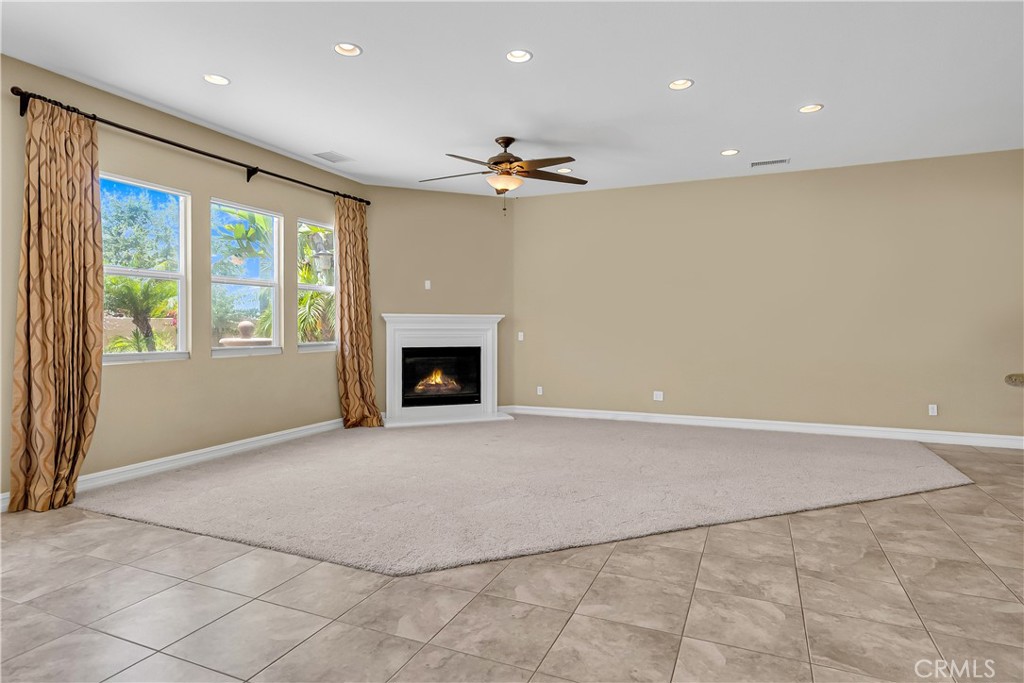 7780 Solitude Court Riverside, CA 92506 - Photo 22 of 63 an empty room with windows fireplace and fan