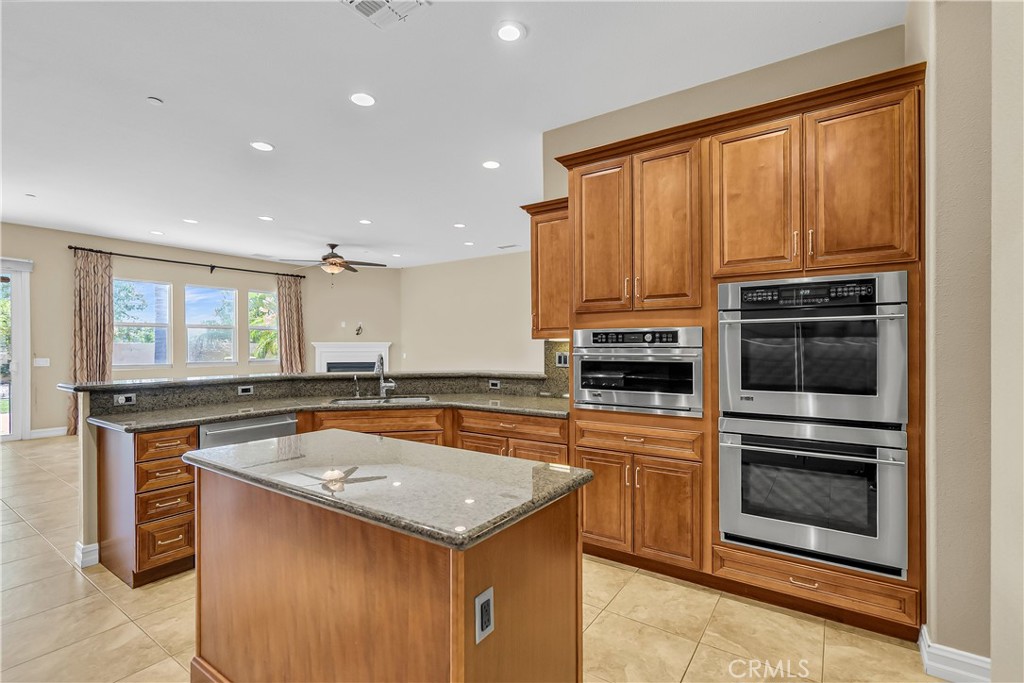 7780 Solitude Court Riverside, CA 92506 - Photo 27 of 63 a kitchen with stainless steel appliances granite countertop a stove a sink and a microwave