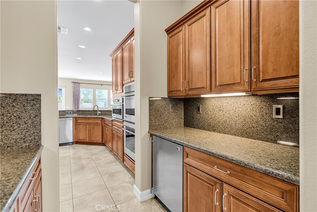 7780 Solitude Court Riverside, CA 92506 - Photo 29 of 63 a kitchen with stainless steel appliances granite countertop a stove a sink and a microwave
