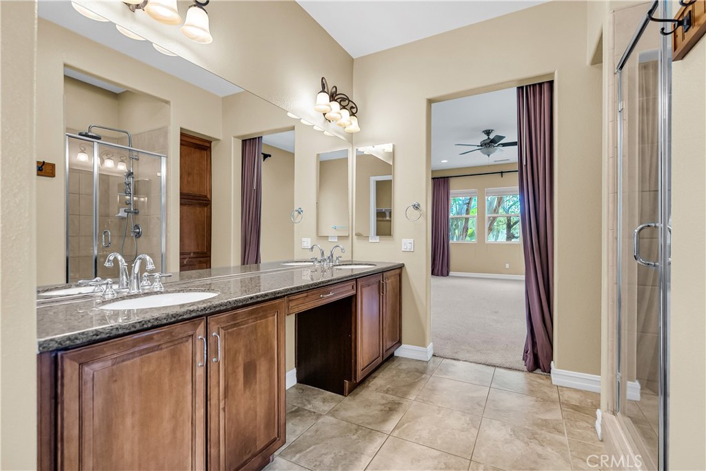 7780 Solitude Court Riverside, CA 92506 - Photo 34 of 63 a bathroom with a granite countertop sink a mirror and a