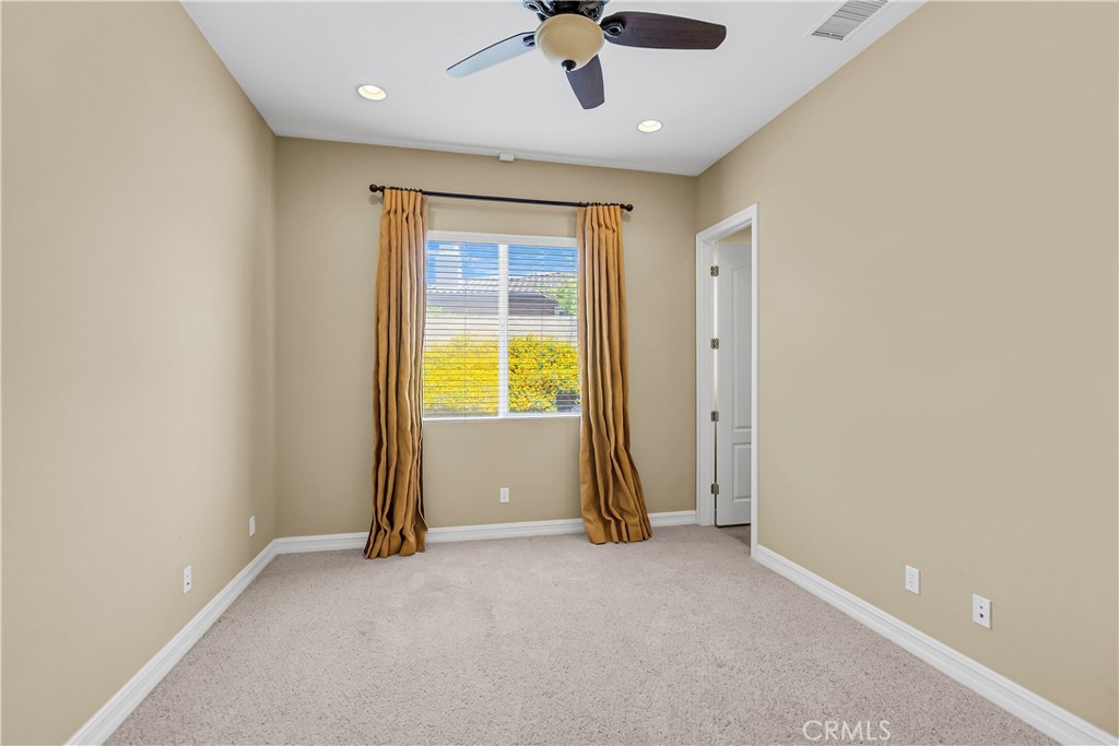 7780 Solitude Court Riverside, CA 92506 - Photo 38 of 63 an empty room with chandelier fan and windows