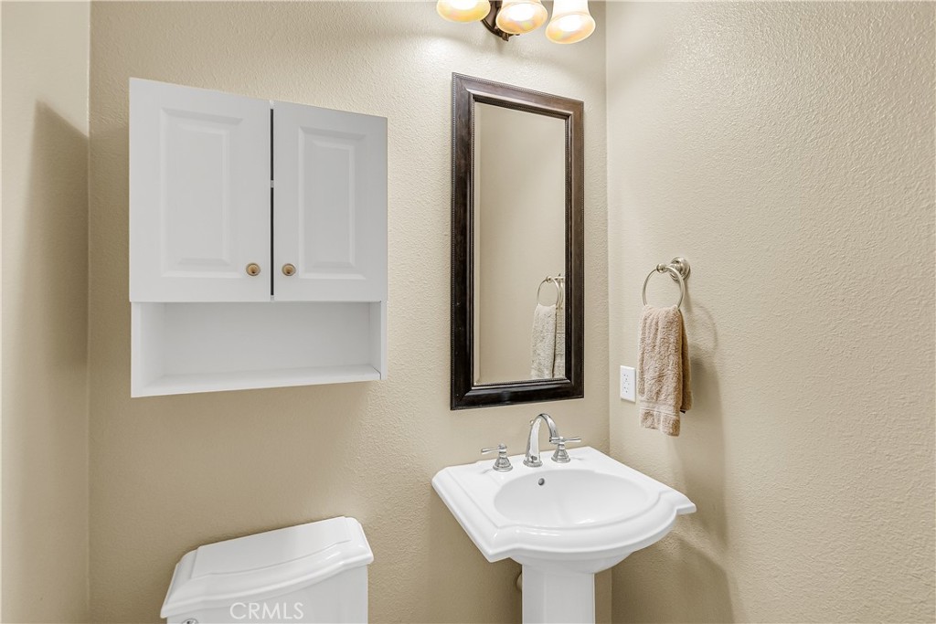 7780 Solitude Court Riverside, CA 92506 - Photo 45 of 63 a bathroom with a toilet sink and mirror