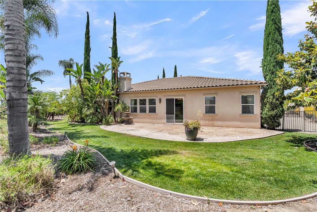 7780 Solitude Court Riverside, CA 92506 - Photo 47 of 63 a white house with a big yard and potted plants