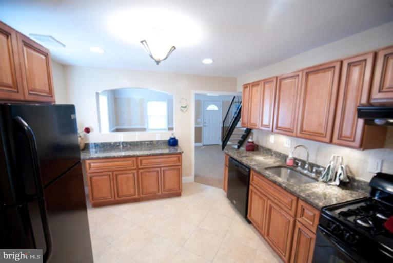 3127 Sollers Point Road Dundalk, MD 21222 - Photo 2 of 14 a kitchen with granite countertop stainless steel appliances and wooden cabinets