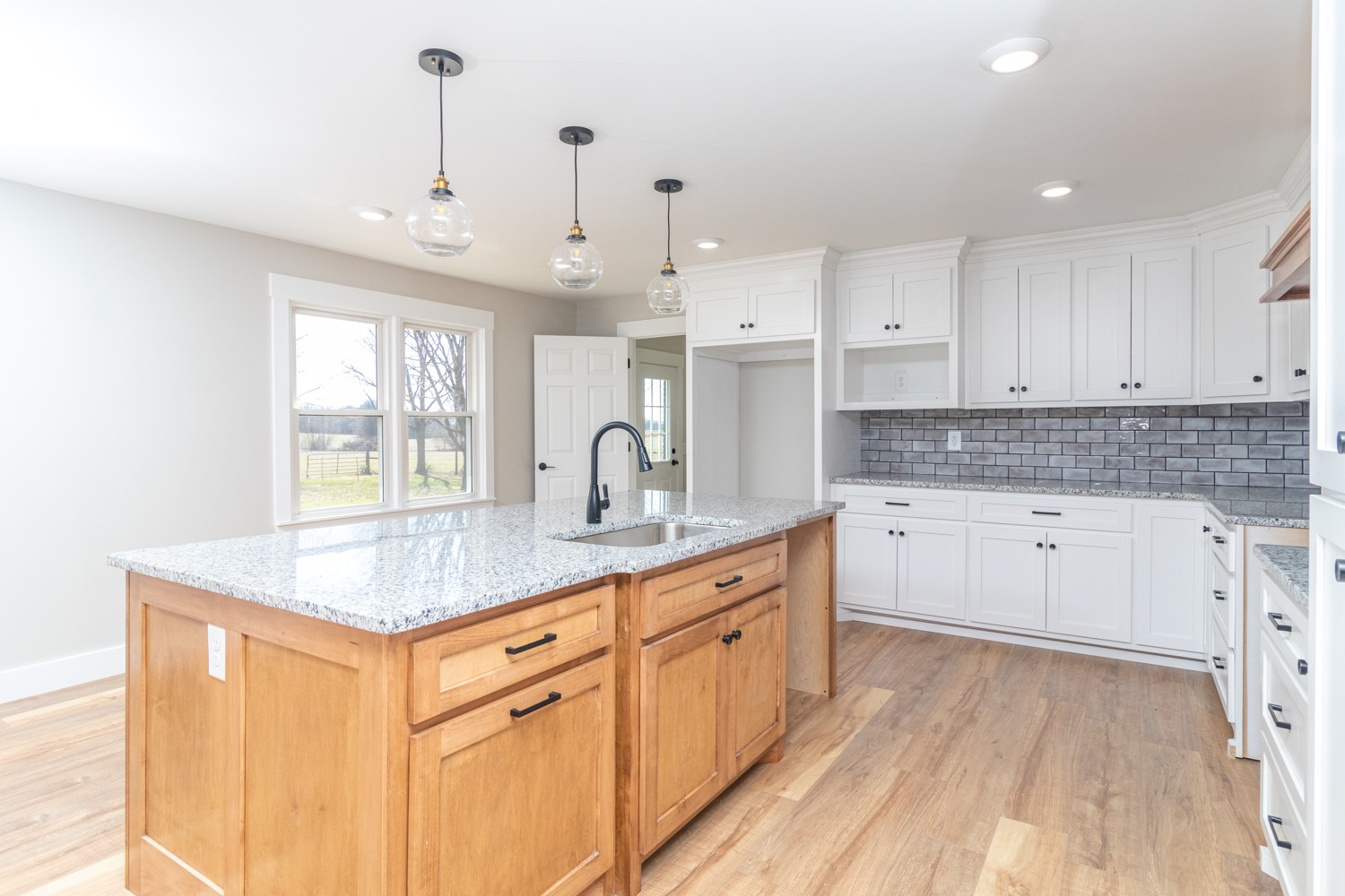 169 Dunn Fall River Road Leoma, TN 38468 - Photo 5 of 34 a kitchen with stainless steel appliances granite countertop a sink dishwasher and white cabinets with wooden floor