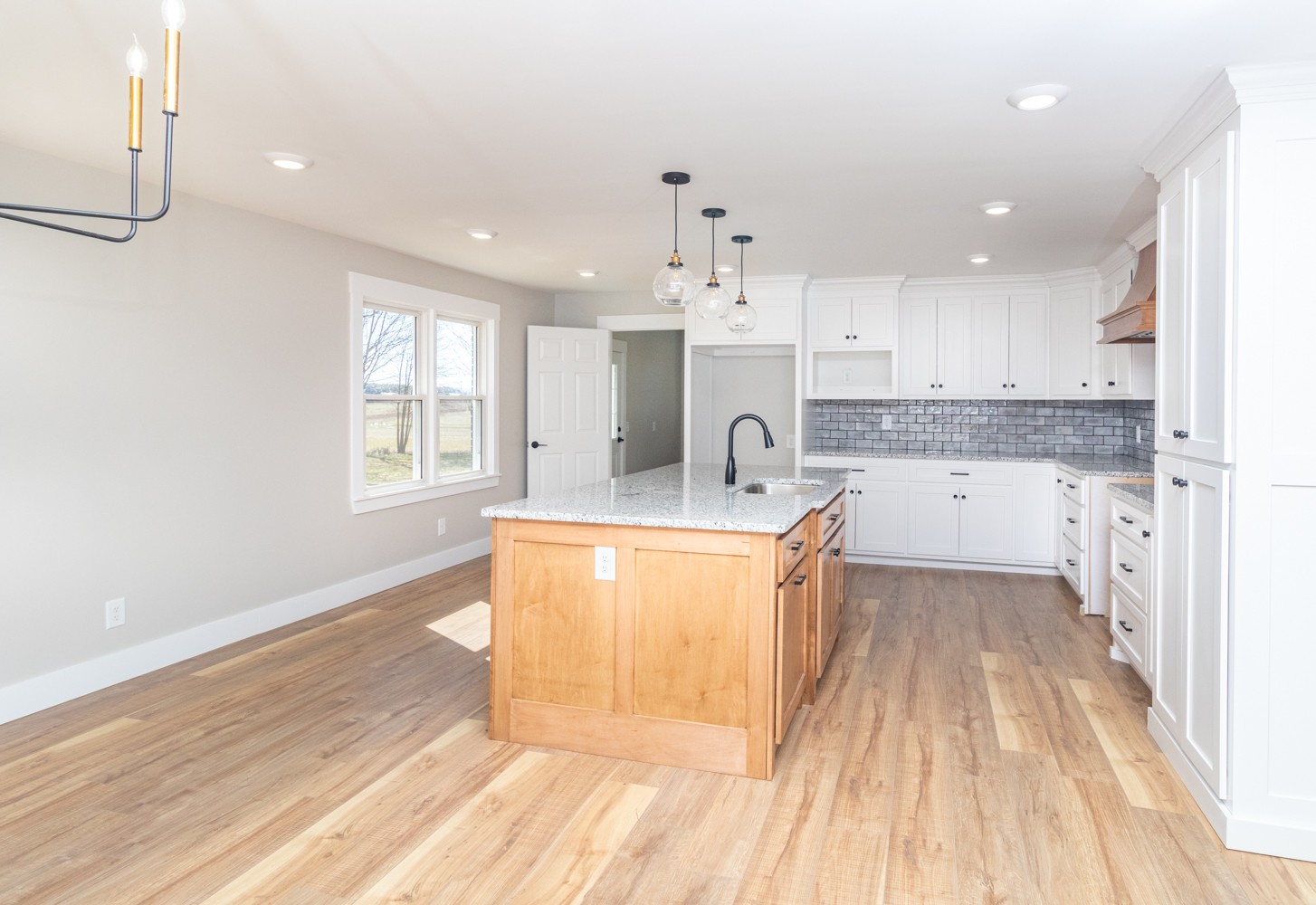 169 Dunn Fall River Road Leoma, TN 38468 - Photo 9 of 34 a large kitchen with stainless steel appliances kitchen island granite countertop a stove a sink a refrigerator and white cabinets with wooden floor