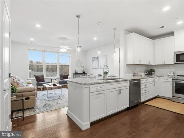 a living room with furniture chandelier and view of kitchen