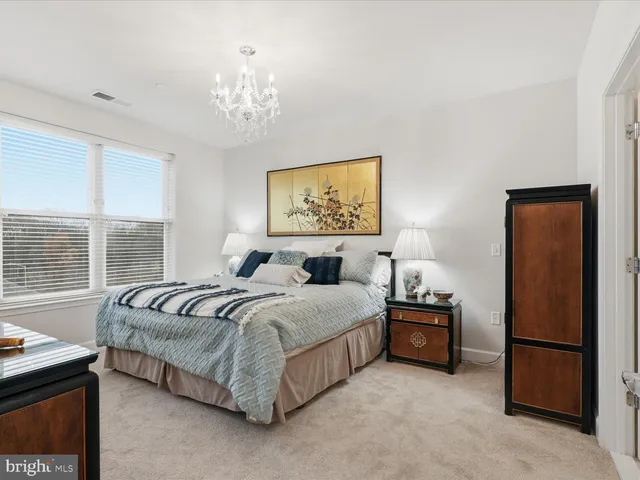a spacious bedroom with a bed and a chandelier
