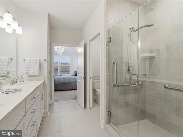 a spacious bathroom with a shower sink and mirror