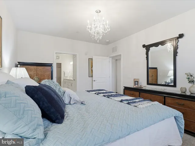 a bedroom with a large bed and a chandelier