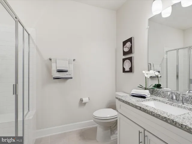 a bathroom with a granite countertop sink a toilet and a mirror