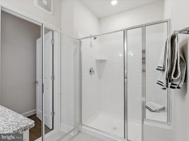 a bathroom with a granite countertop shower and a sink
