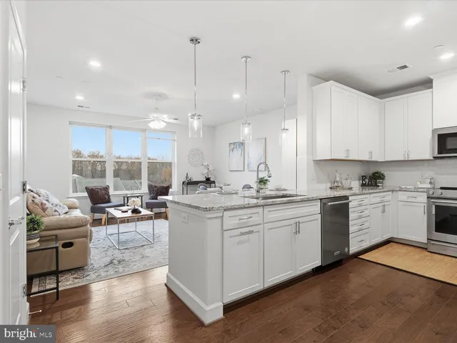 a kitchen with stainless steel appliances kitchen island granite countertop a sink and cabinets