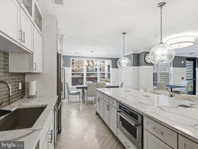 a large kitchen with kitchen island a large counter space stainless steel appliances and cabinets