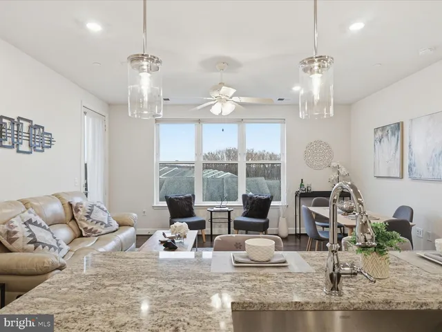 a living room with furniture chandelier and view of kitchen