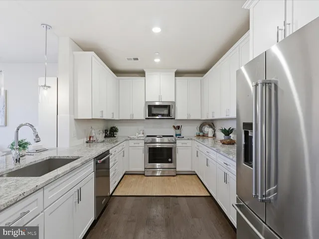 a kitchen with granite countertop a sink stove and refrigerator