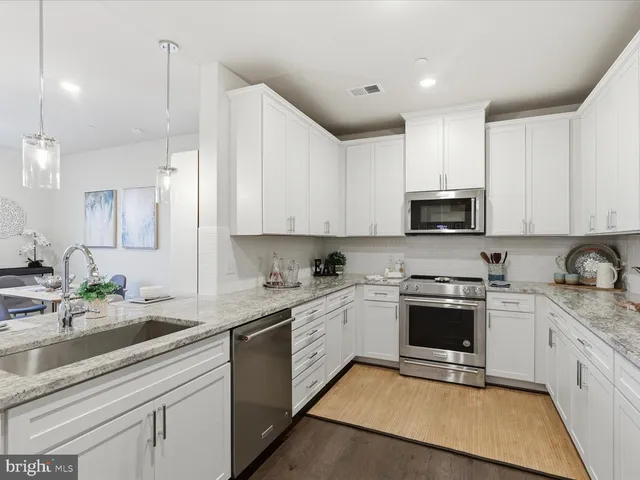 a kitchen with stainless steel appliances granite countertop a sink stove and microwave