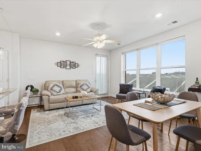 a living room with furniture kitchen view and a large window