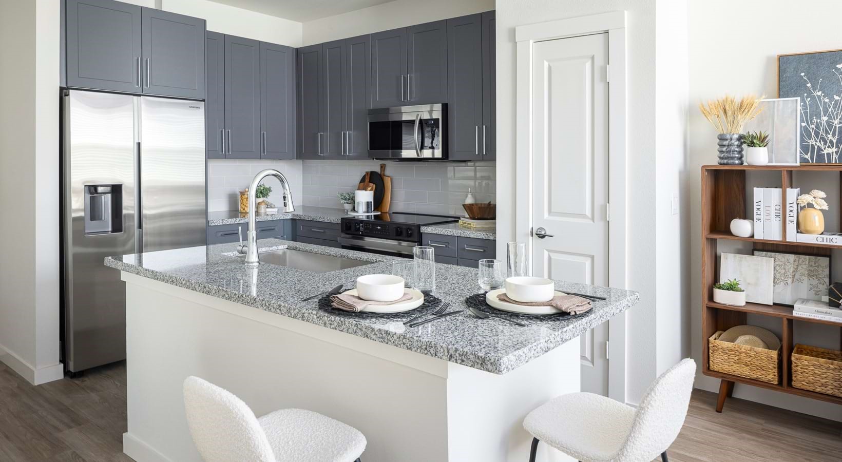 1505 Oliver Street, Unit 101 Houston, TX 77007 - Photo 7 of 19 a kitchen with granite countertop a sink and a stove with wooden floor
