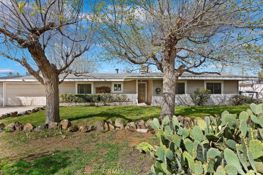 22406 Miramot Road Apple Valley, CA 92308 - Photo 1 of 1 a front view of a house with garden