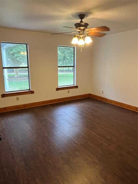 1401 Linton Road Benton, LA 71006 - Photo 11 of 19 an empty room with wooden floor chandelier fan and windows