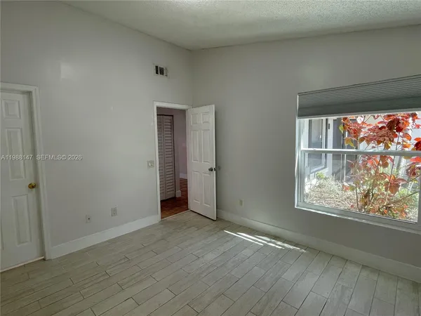 an empty room with wooden floor and a window