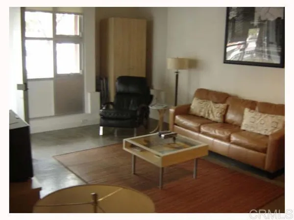 a living room with furniture a rug and a window